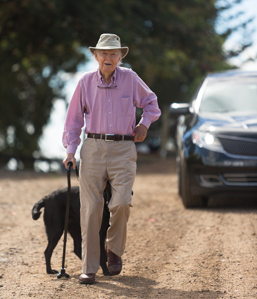 Davis Bynum walking down a dirt road with his dog